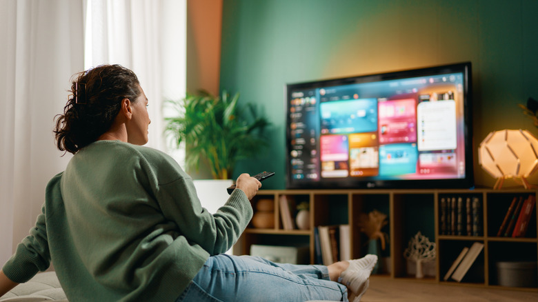 woman at home deciding what to watch on a TV streaming service