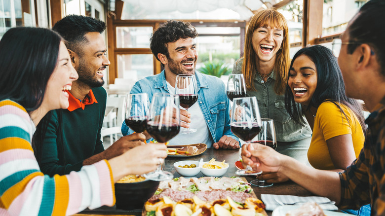 A group of friends enjoying wine with dinner