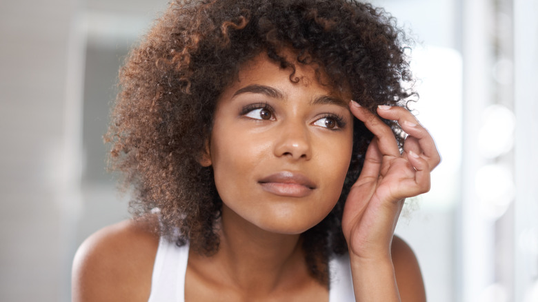 Woman looking at her eyes