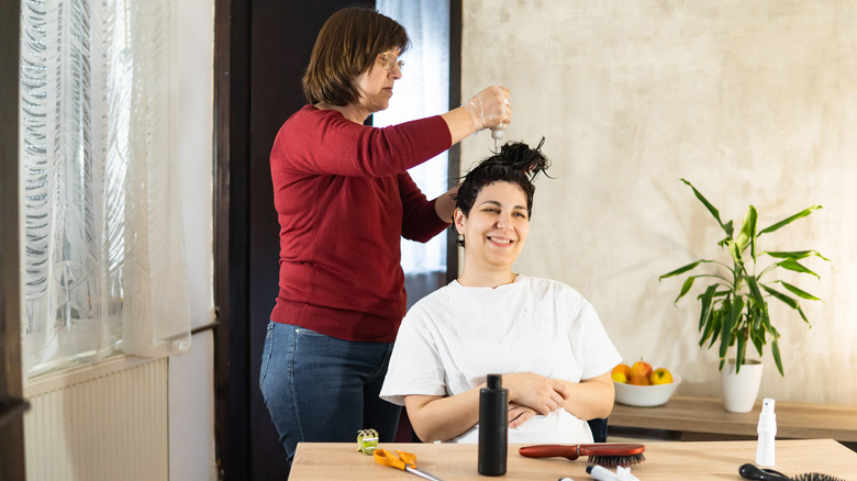 Pregnant woman getting hair dyed at home