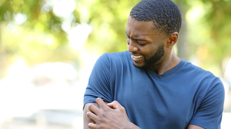 man scratching his arm