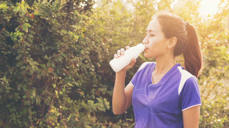 Female athlete drinking Fairlife milk outside