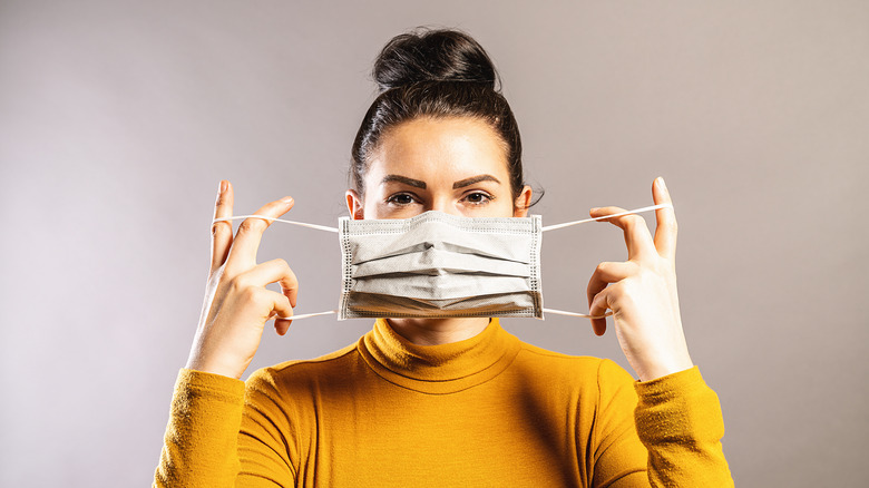 woman removing mask