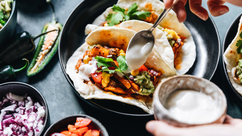 spooning yogurt on tacos