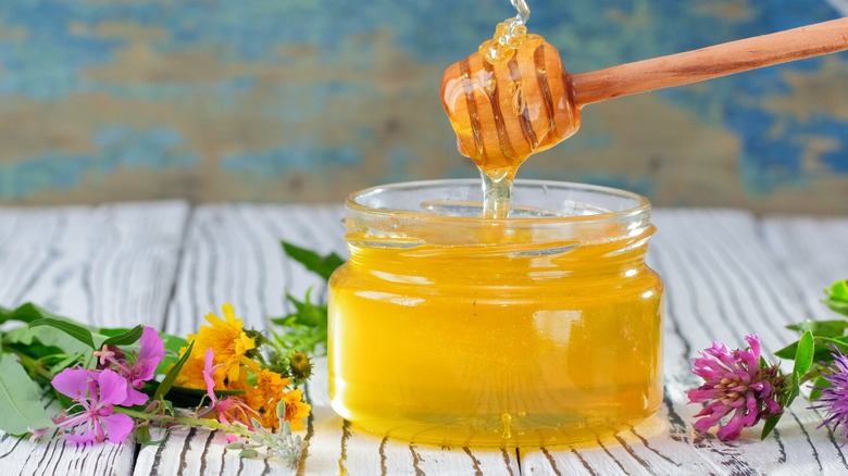 honey in glass jar with dipper