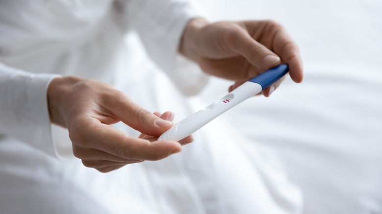 Closeup view of hands holding a positive pregnancy test