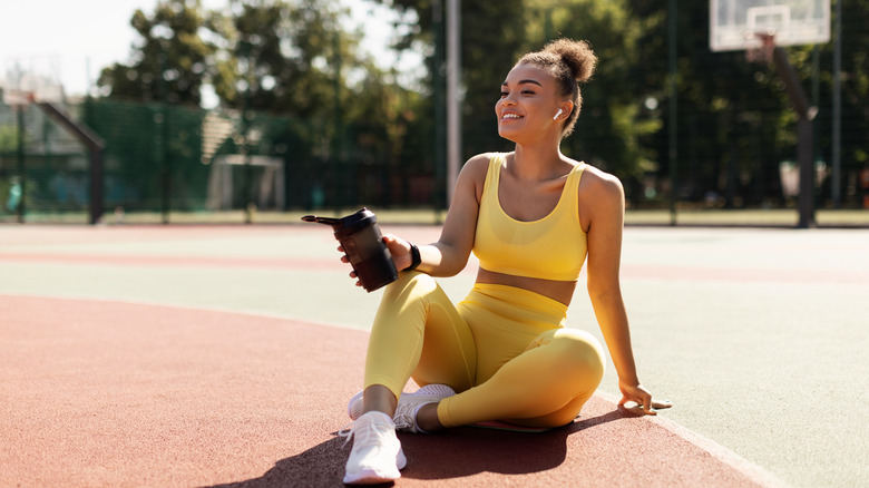 Black woman drinking before exercise