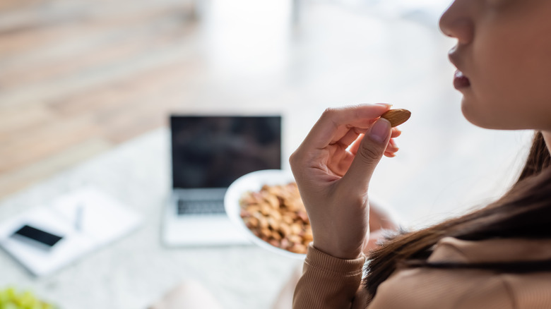 A woman snacks on almonds