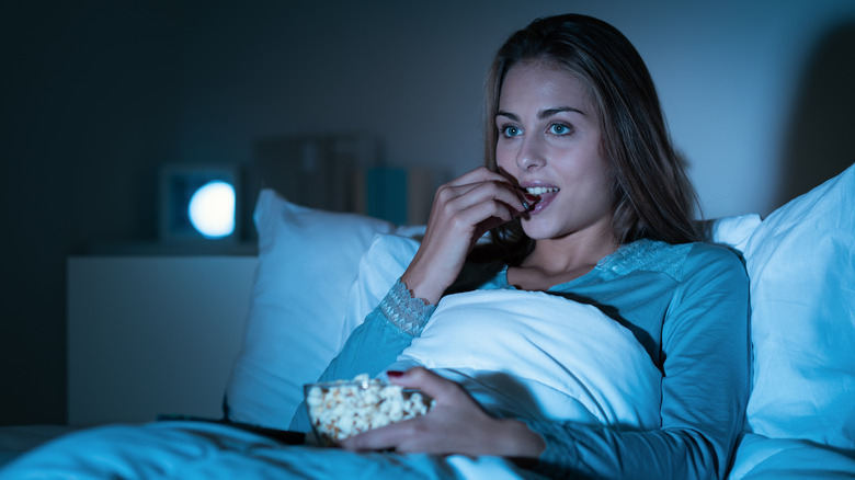 A woman snacks before bed