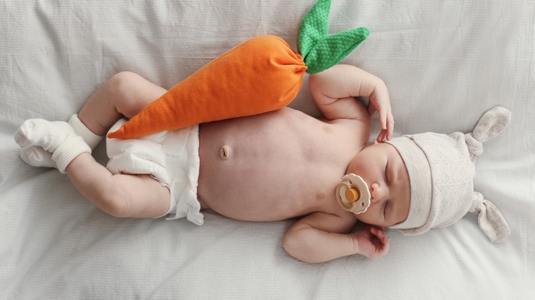 infant sleeping with plush carrot