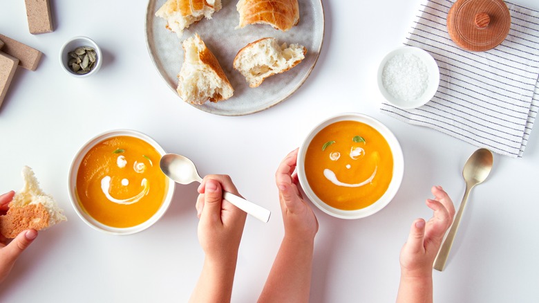 two bowls of pumpkin soup with smiley faces  