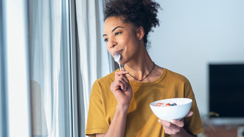 a young woman enjoying yogurt 