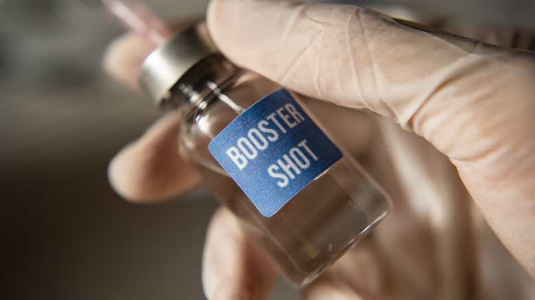 Someone holds the COVID-19 booster shot
