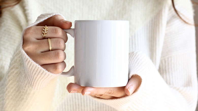 A woman holds a cup of coffee