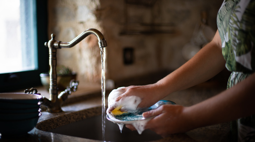 woman washing dishes in sink