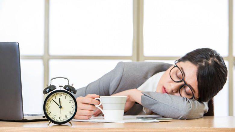 A woman sleeping at her desk at her office