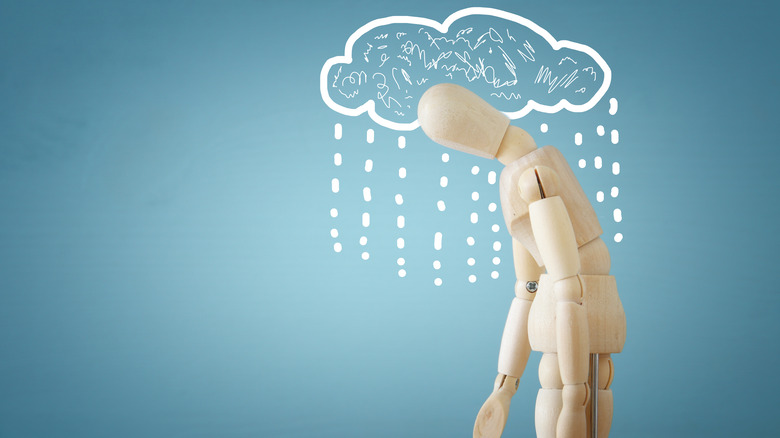 wooden figure under illustrated rain cloud