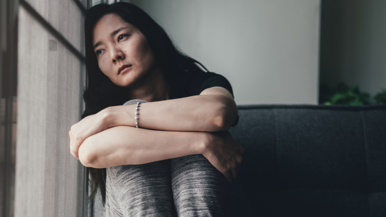 woman looking forlorn on couch