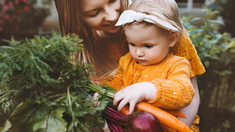 mom and child holding carrots