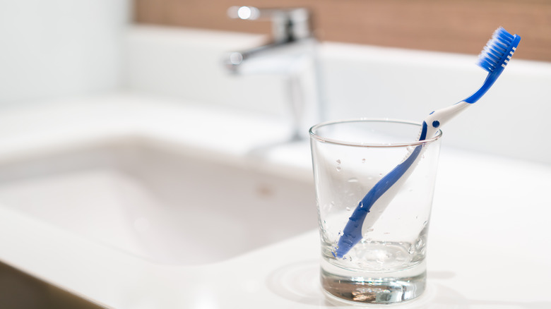 Toothbrush in cup on sink