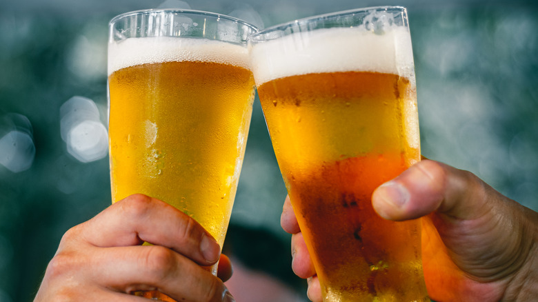 People toasting with beer in glasses