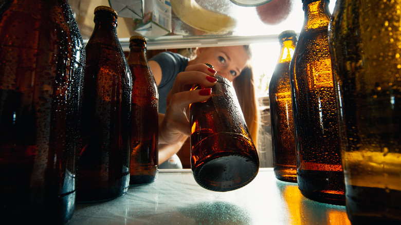 woman grabbing a beer from the fridge