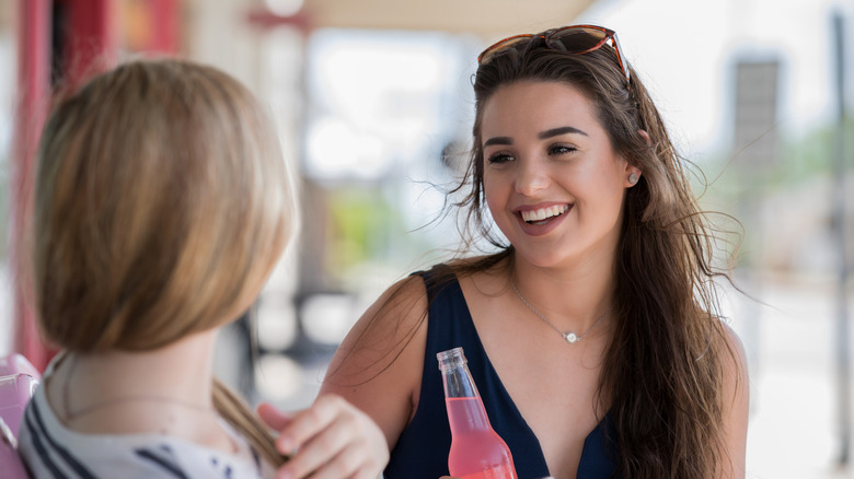 women drinking bottles soda