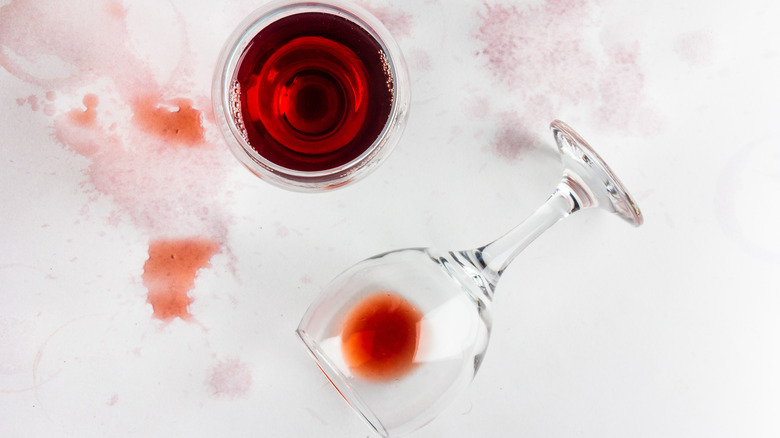 full glass of red wine and spilled glass