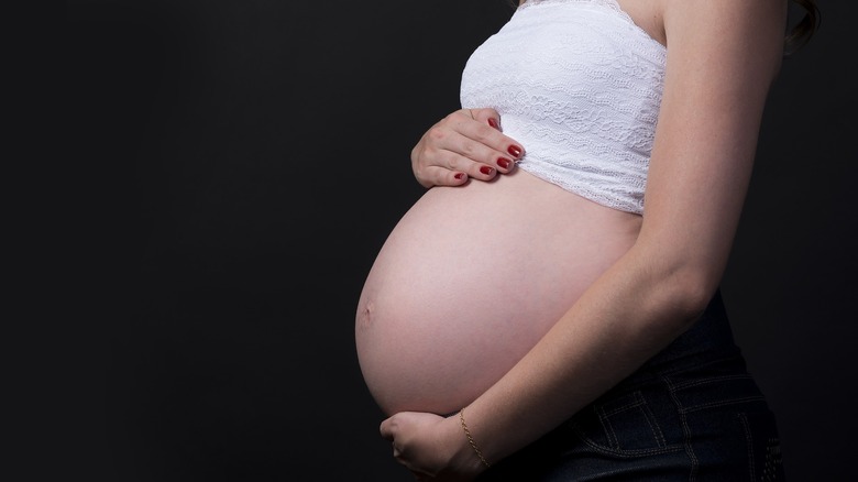 Pregnant woman holding belly