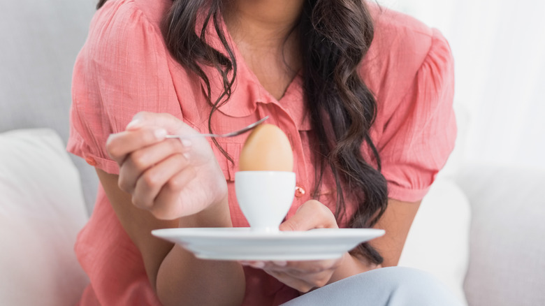 woman holding a dish with a hard-boiled egg