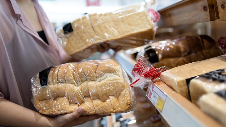 Person holding loaves of bread