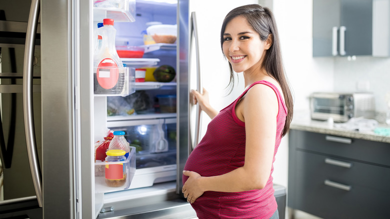 pregnant woman deciding what to eat