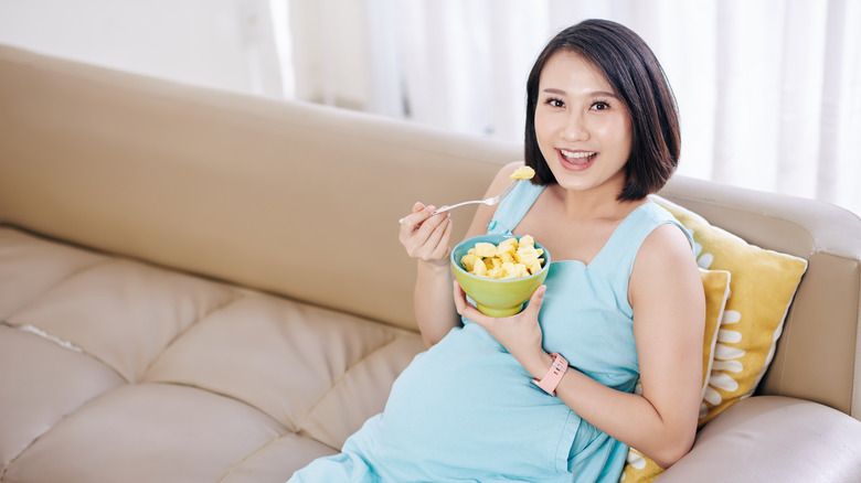 Pregnant woman eating pineapple