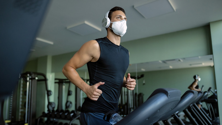 man with mask on treadmill