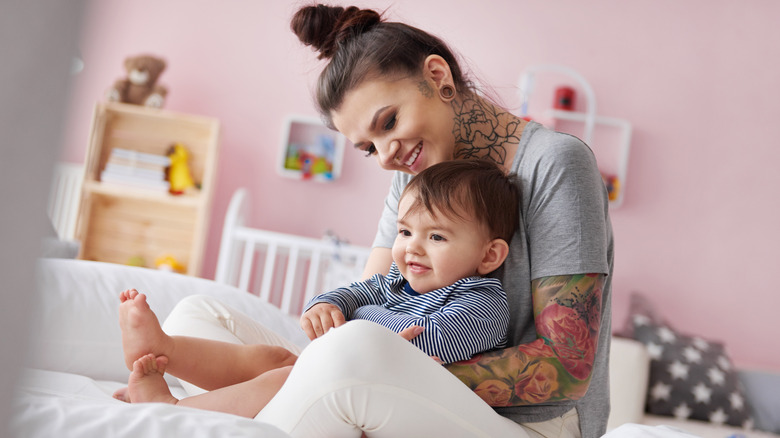 tattooed mom holds infant son 