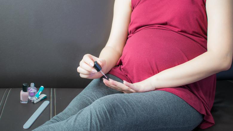 Pregnant woman painting nails