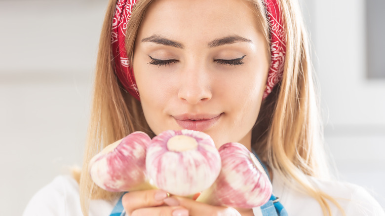 Woman smelling fresh garlic in her hands