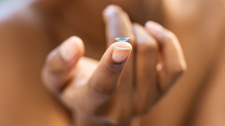 African girl holding contact lens