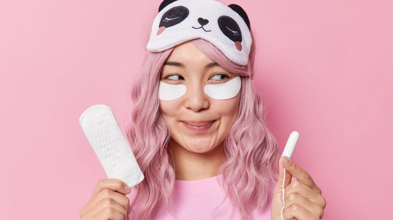 Woman holding pantyliner and tampon