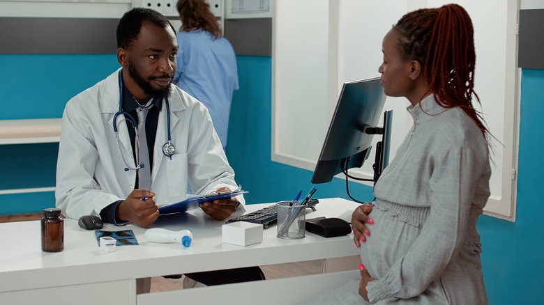 Pregnant person speaking to doctor