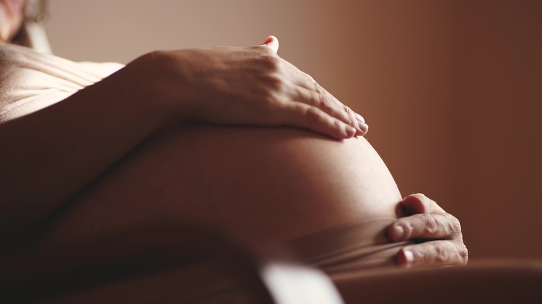 pregnant woman holding belly