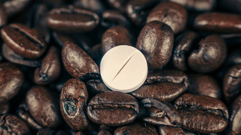 Pill surrounded by coffee beans