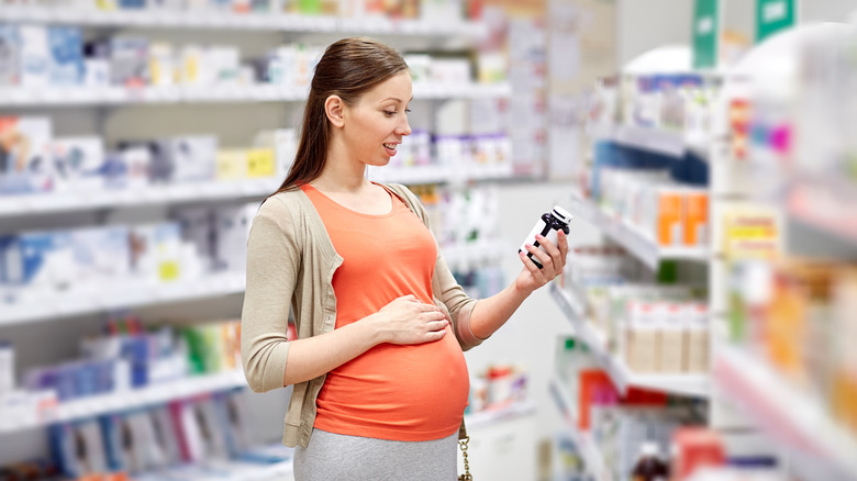 Pregnant person reading medication label