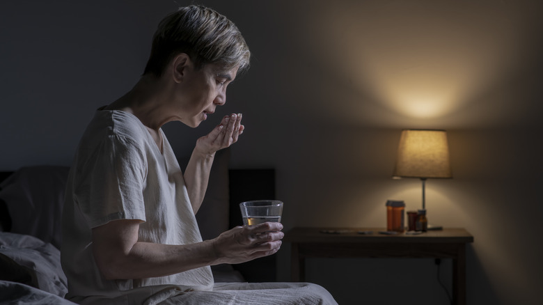 older woman taking medication before bed