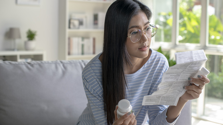 woman looking at information sheet for medication