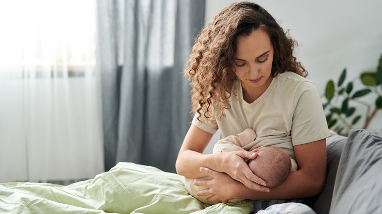 Mother breastfeeding baby in bed