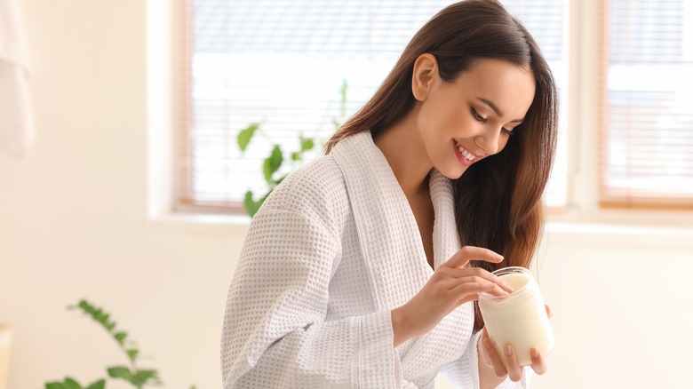 Woman holding jar of coconut oil 
