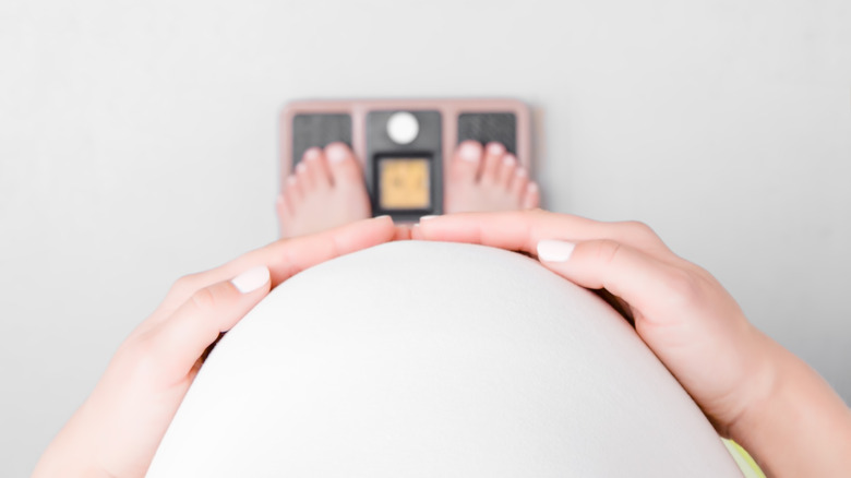 Pregnant person weighing themselves