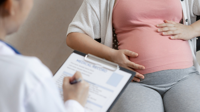 Doctor consulting with pregnant patient