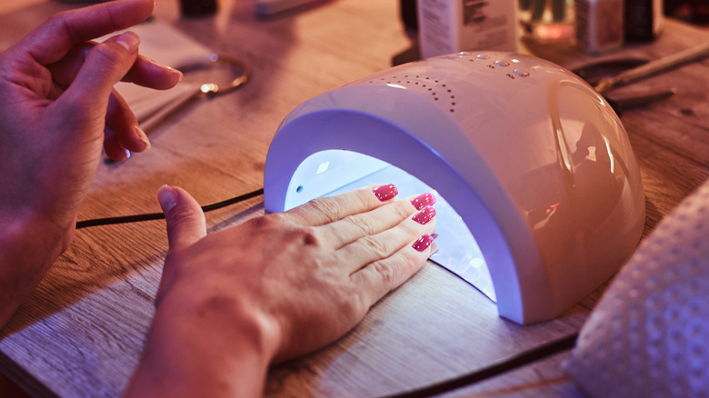 Manicured hand inside UV light dryer